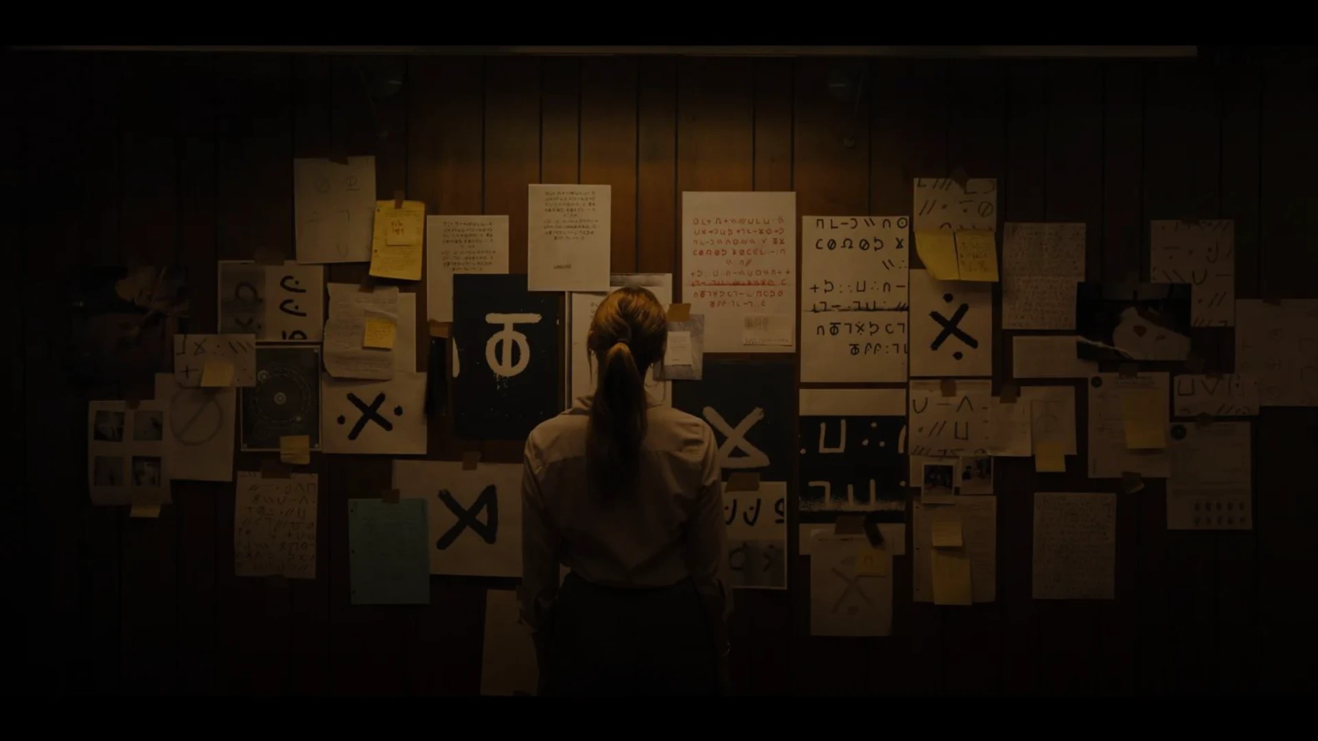 Maika Monroe in 'Longlegs.' looking at a board NEON